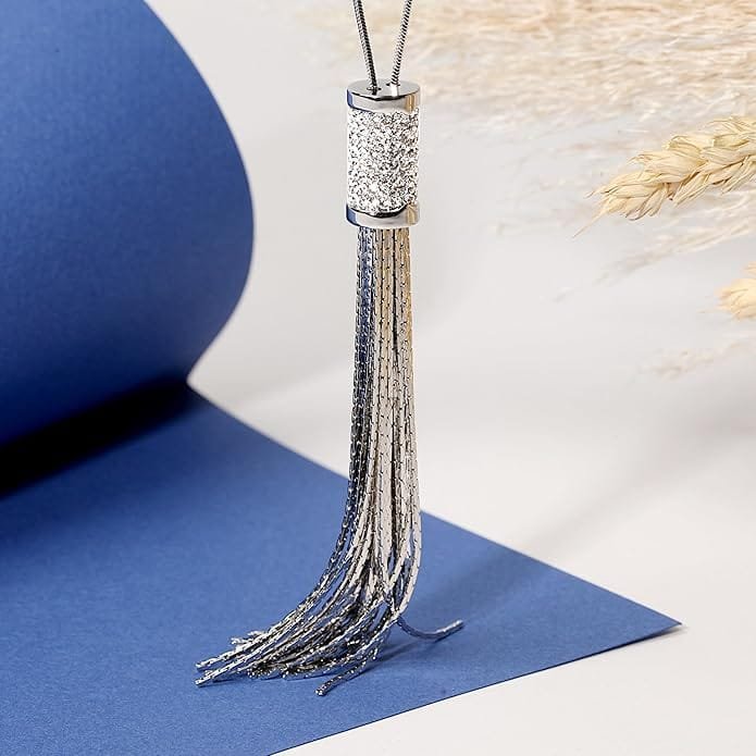 Collier sautoir femme argenté avec pendentif tassel en acier inoxydable présenté sur fond bleu