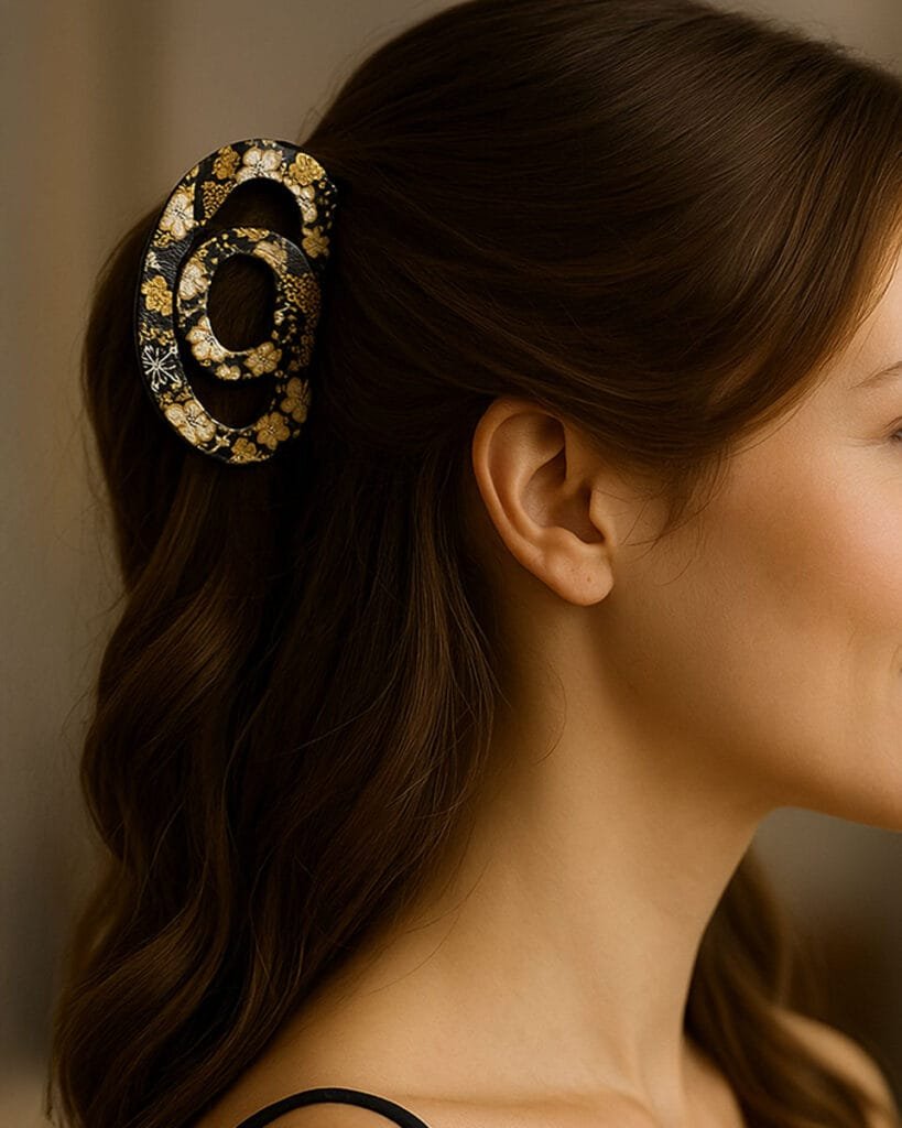 Accessoire cheveux japonais porté par une femme de profil – pince noire à motif floral or et ivoire ClawMeUp