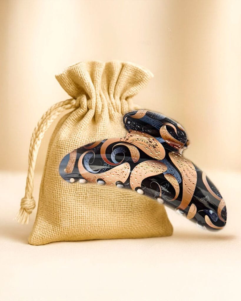 Idée cadeau pour maman qui a tout : une pince à cheveux artistique ClawMeUp posée devant un pochon élégant en toile naturelle