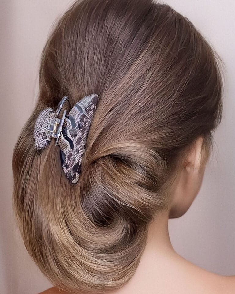 Femme de dos avec un chignon élégant maintenu par une pince cheveux épais ClawMeUp en motif python