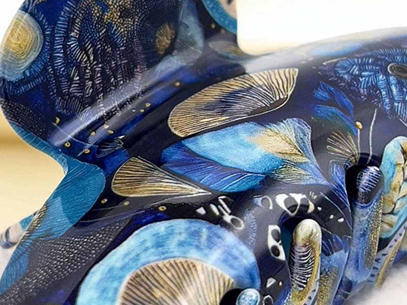 Gros plan sur une pince à cheveux ClawMeUp – Design artistique bleu et doré inspiré par la nature et l’art contemporain