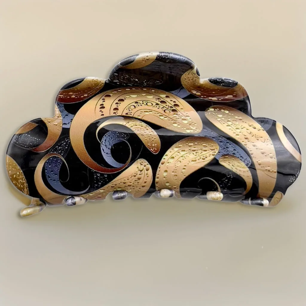 Pince à cheveux en acétate noir et doré sur fond champagne dégradé, ombre douce