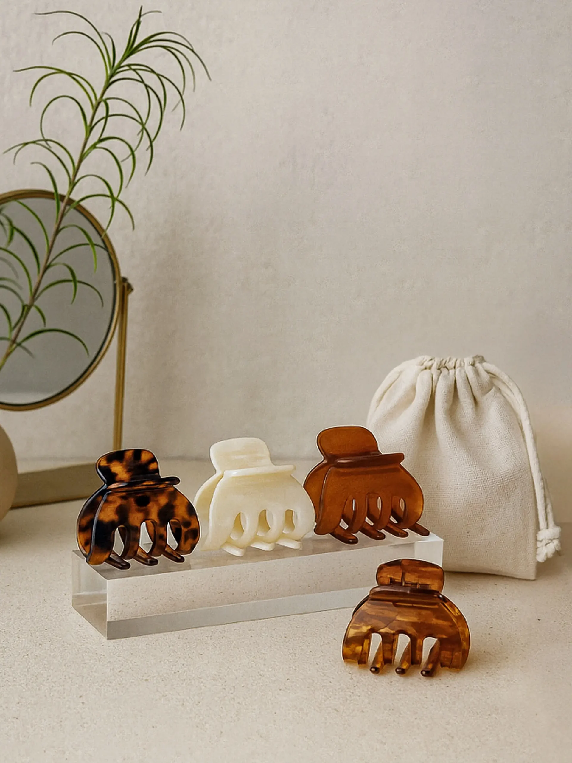 Pinces à cheveux ClawMeUp présentées sur support acrylique avec pochette en lin – catalogue professionnel élégant