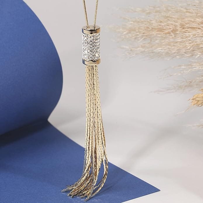 Collier long femme doré avec pendentif tassel en acier inoxydable présenté sur fond bleu