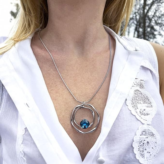 Collier pendentif femme argenté porté, avec pendentif cercle ajouré et pierre bleue