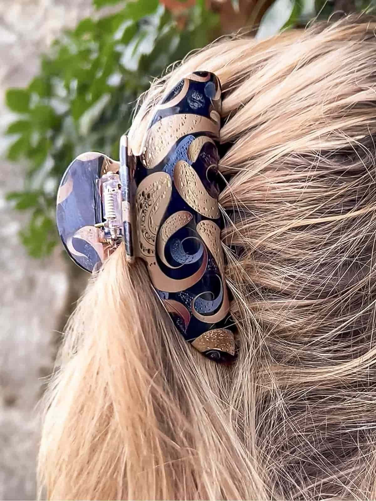 Coiffure blonde élégante avec une pince à cheveux ClawMeUp noire et dorée