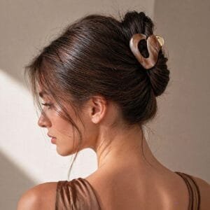 Pince à cheveux design organique courbe acétate écaille caramel portée en chignon bun cheveux bruns — CMU-ABS-01 ClawMeUp