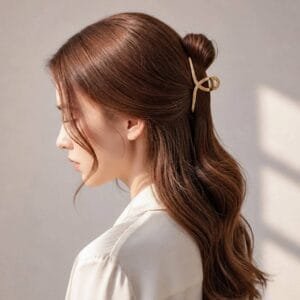 Petite pince à cheveux métal Dorée portée en demi-chignon, cheveux longs ondulés, vue profil — ClawMeUp Paris