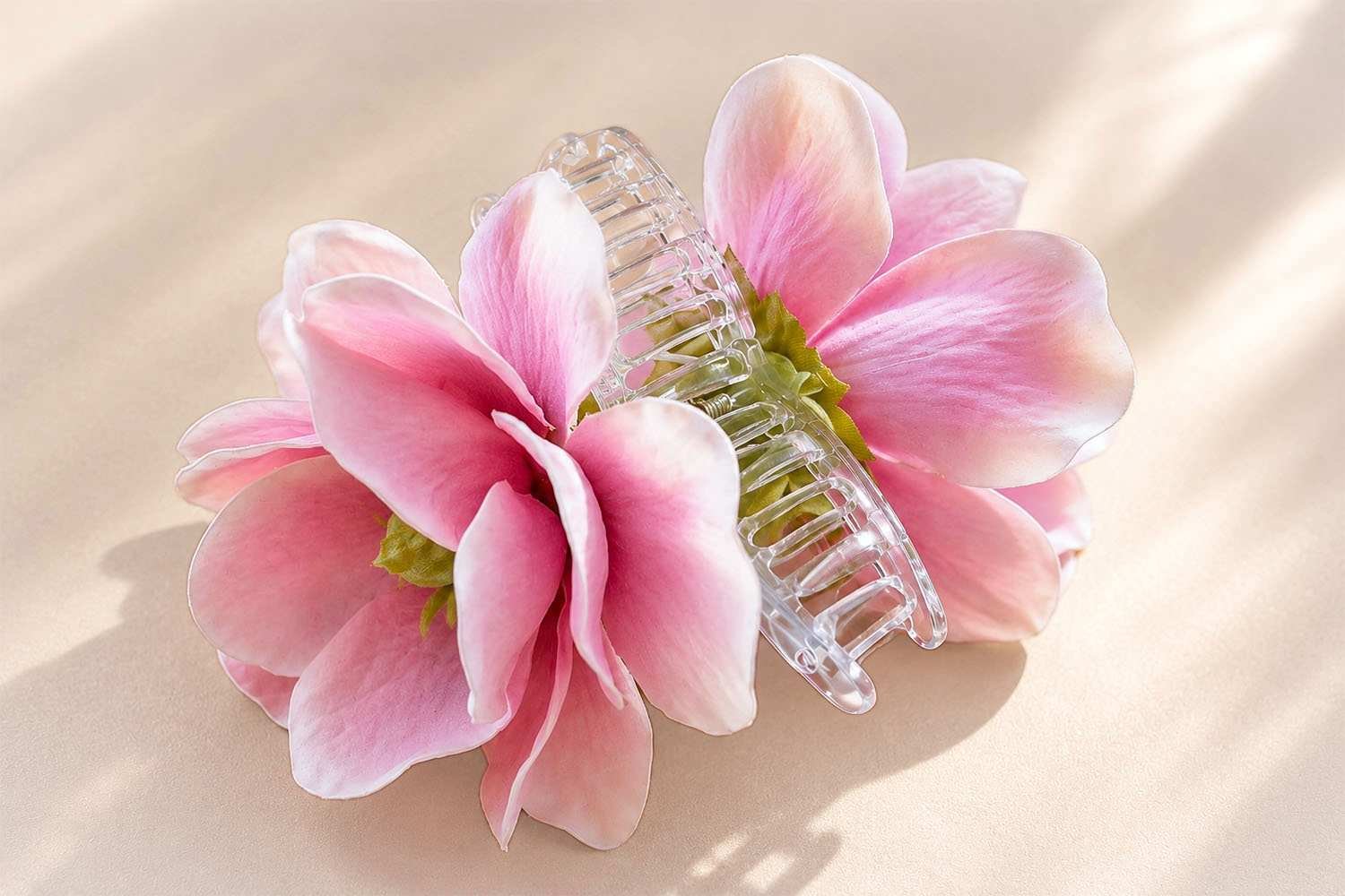 Pince à cheveux fleur rose ClawMeUp en acétate de cellulose transparent, composition florale magnolia sur fond beige