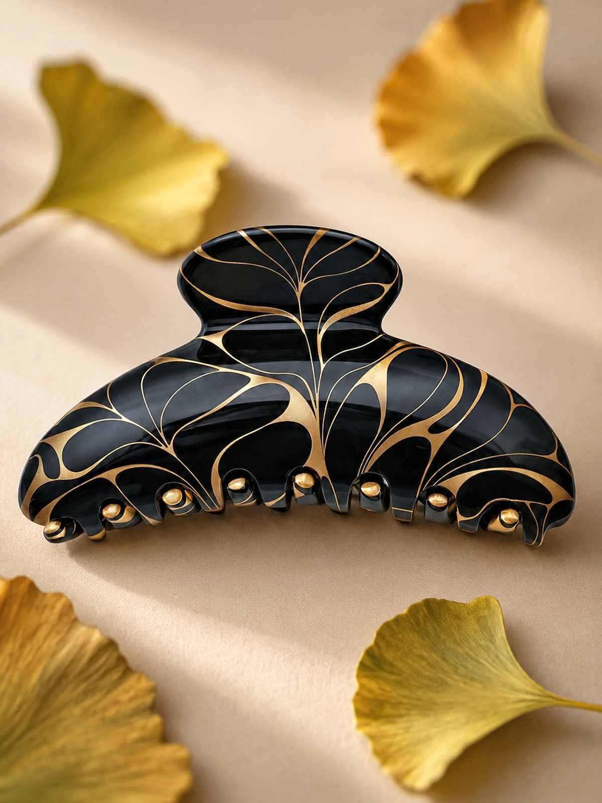 Pince crabe cheveux originale en acétate de cellulose noir et or, motif Art Nouveau aux arabesques dorées, entourée de feuilles de ginkgo — ClawMeUp Paris