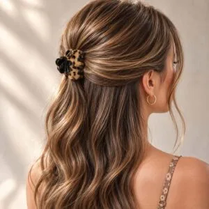 Demi-queue portée avec une pince à cheveux fleur noire en acétate coloris écaille miel